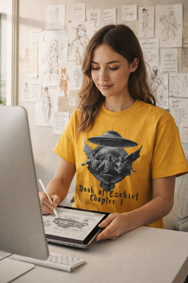 Woman in yellow t-shirt with graphic design sitting at a desk using a tablet.