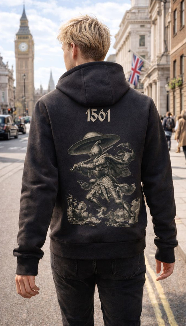 Person wearing a black hoodie with a graphic UFO design and '1561' on the back, standing in a city street.