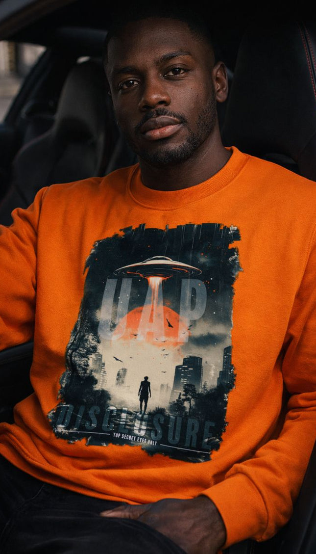 Man wearing an orange sweatshirt with a graphic design inside a car.