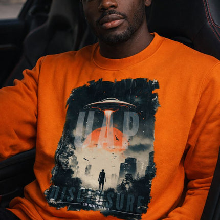 Man wearing an orange sweatshirt with a graphic design inside a car.